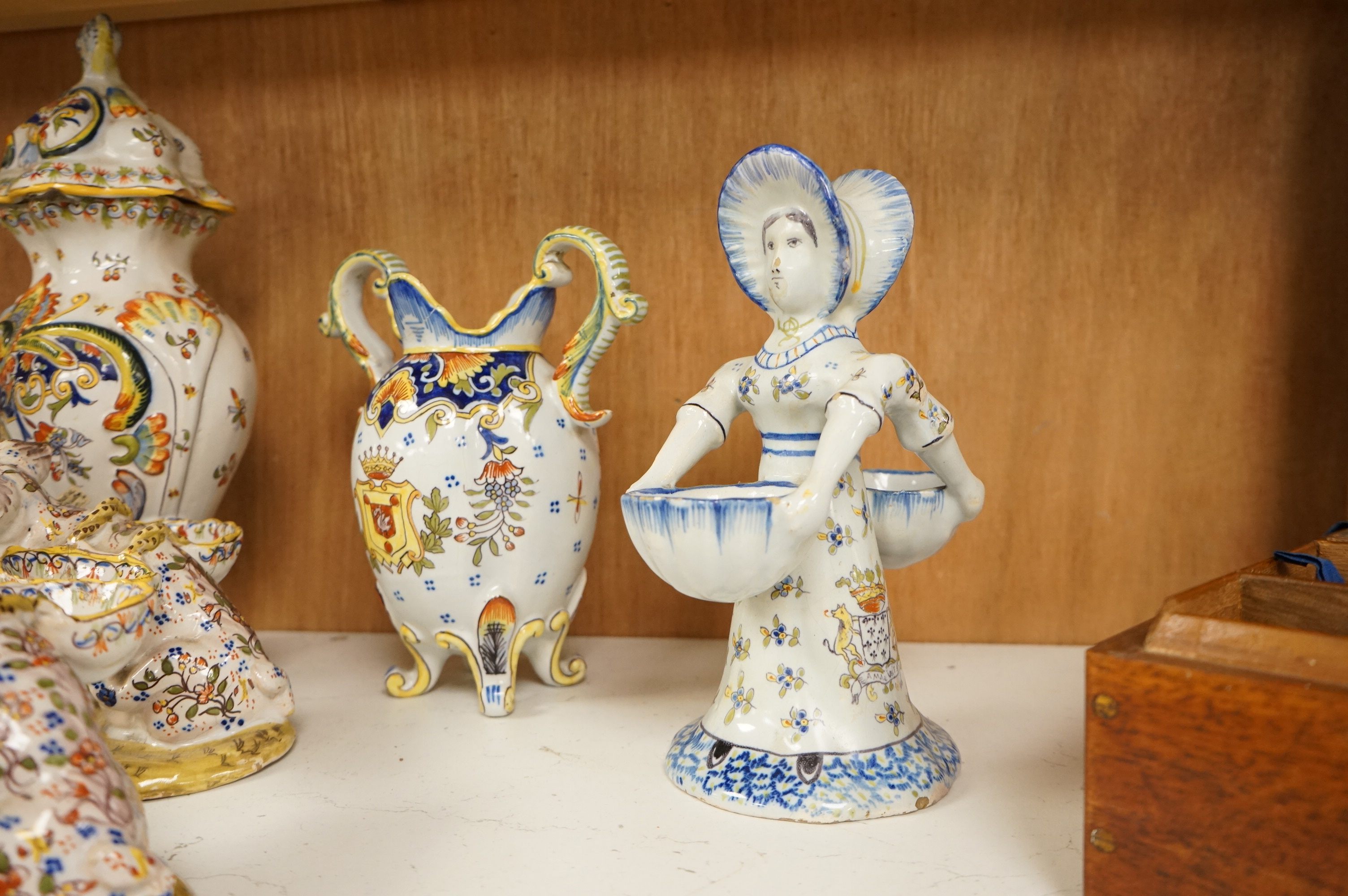 A collection of early 20th century French faience pieces to include a pair of salts in the form of pigs and candlesticks, largest 27cm high